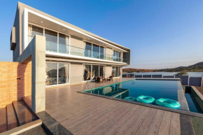 StayVista's Bellisimo Panorama - Lakeside Oasis with Infinity Pool, Modern Interiors, Open-to-Sky Bathtub, and Lush Green Lawn